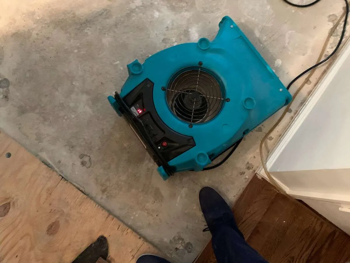 Air mover drying subfloor during Commercial Water Damage Restoration in Newburgh